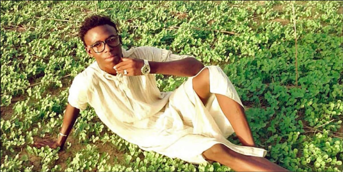 A man relaxing on a field of green.
