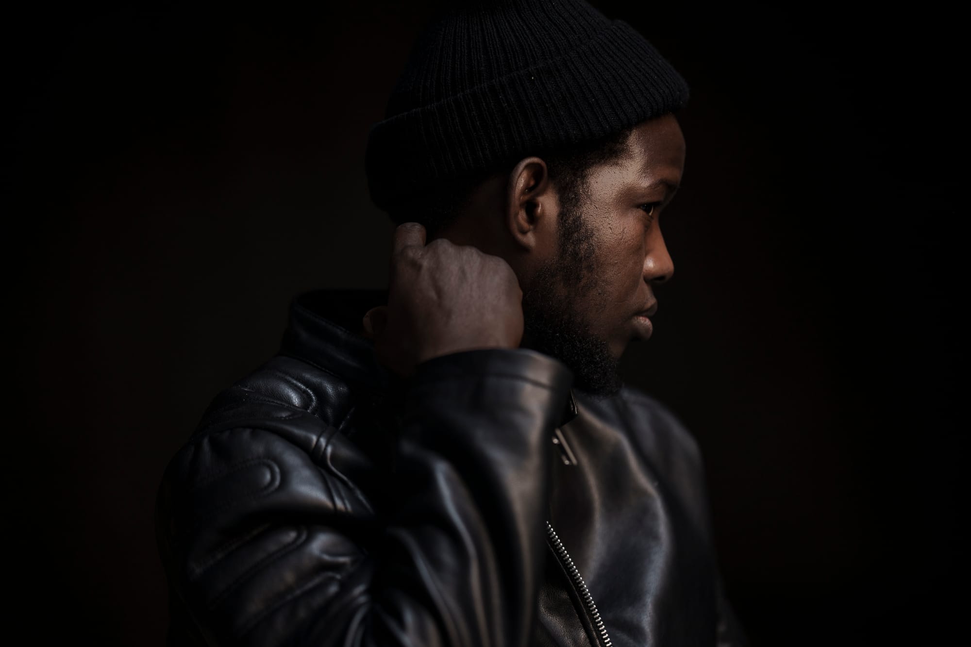 Close up of a man in a leather jacket in profile.